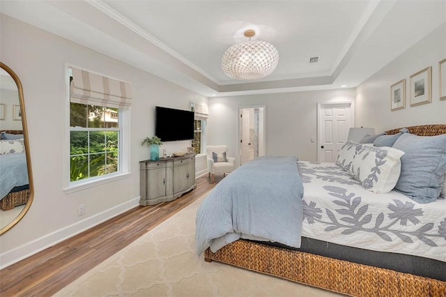 19 Wimbledon Ct, Saint Simons Island, GA 31522 - bedroom featuring a raised ceiling, wood finished floors, and a chandelier