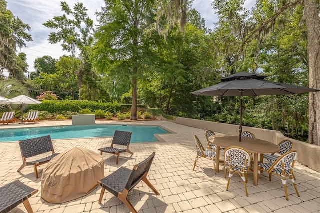 19 Wimbledon Ct, Saint Simons Island, GA 31522 - view of pool with a patio, view of wooded area, and outdoor dining space
