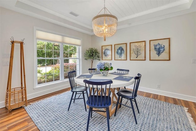 19 Wimbledon Ct, Saint Simons Island, GA 31522 - dining room with a chandelier, wood finished floors, a tray ceiling, and ornamental molding