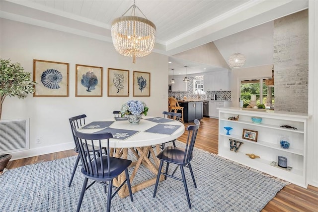 19 Wimbledon Ct, Saint Simons Island, GA 31522 - dining room featuring a chandelier, wood finished floors, crown molding, and lofted ceiling