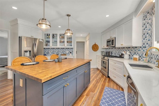 19 Wimbledon Ct, Saint Simons Island, GA 31522 - kitchen featuring appliances with stainless steel finishes, wooden counters, white cabinetry, decorative backsplash, and recessed lighting