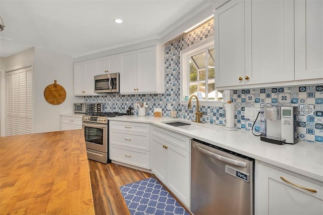 19 Wimbledon Ct, Saint Simons Island, GA 31522 - kitchen with appliances with stainless steel finishes, backsplash, butcher block countertops, white cabinetry, and recessed lighting