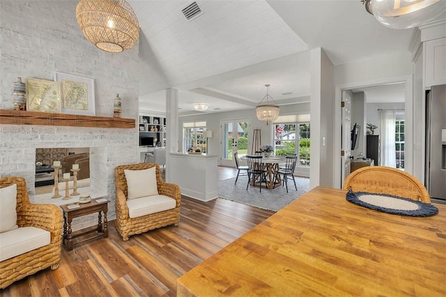19 Wimbledon Ct, Saint Simons Island, GA 31522 - living area with wood finished floors, a large fireplace, and a chandelier