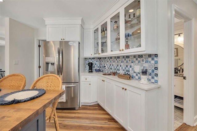 19 Wimbledon Ct, Saint Simons Island, GA 31522 - kitchen featuring stainless steel fridge, light countertops, decorative backsplash, and light wood-style flooring