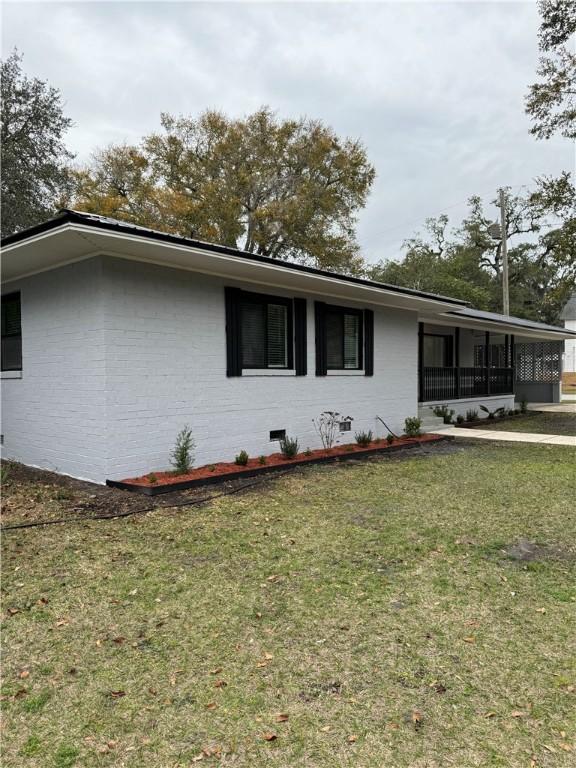 exterior space featuring a sunroom and a lawn