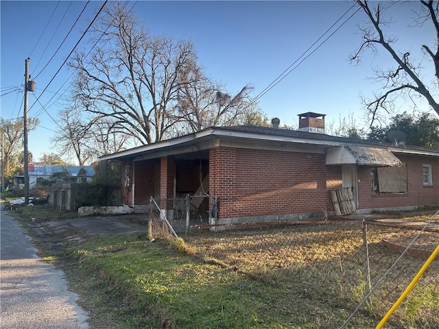 view of side of property with brick siding and a chimney