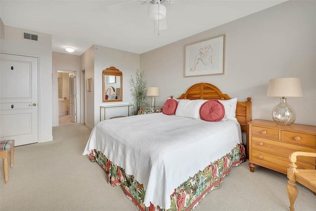 bedroom featuring ceiling fan, connected bathroom, and light carpet