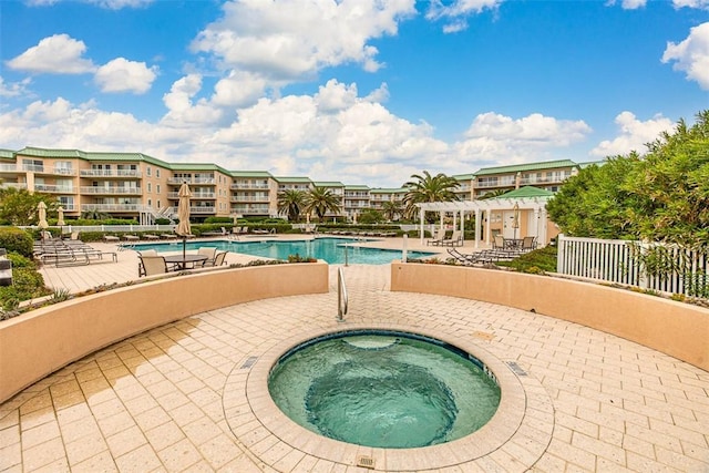 view of swimming pool with a community hot tub, a pergola, and a patio area