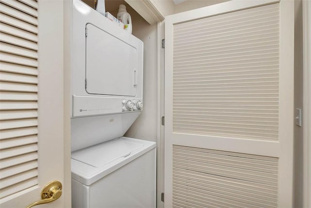 clothes washing area featuring stacked washer and clothes dryer