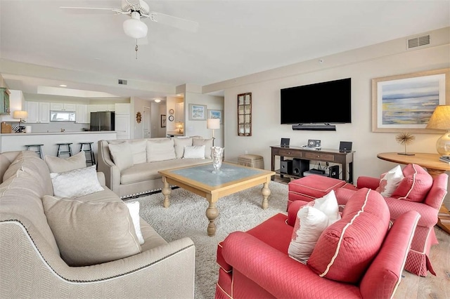 living room featuring light hardwood / wood-style floors and ceiling fan