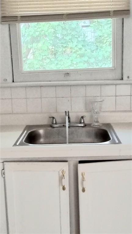 605 Walker St, Waycross, GA 31503 - kitchen view of decorative backsplash, white cabinetry, and light countertops