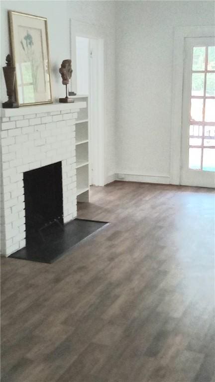 605 Walker St, Waycross, GA 31503 - unfurnished living room with wood finished floors and a fireplace