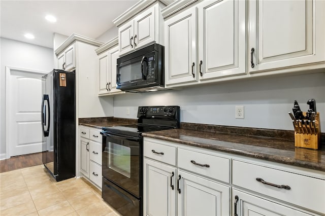 kitchen with light tile patterned floors, recessed lighting, white cabinetry, black appliances, and dark countertops