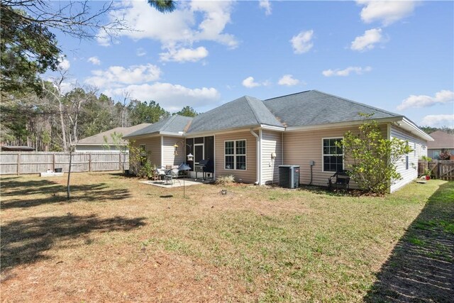 back of house with a patio, central AC unit, a fenced backyard, a yard, and roof with shingles