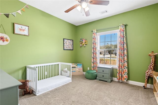 carpeted bedroom with a nursery area, ceiling fan, visible vents, and baseboards