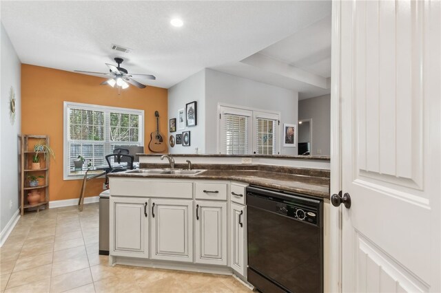 kitchen with black dishwasher, light tile patterned floors, dark countertops, visible vents, and a sink