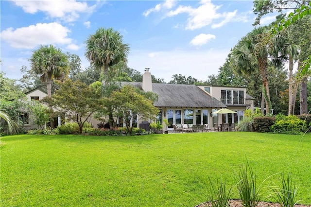 back of house with a patio area and a lawn