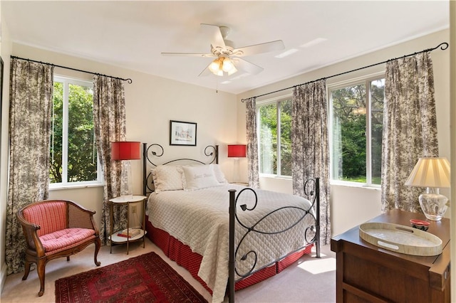 carpeted bedroom with multiple windows and ceiling fan