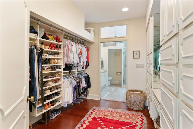 walk in closet with wood finished floors