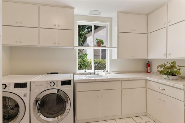 laundry area featuring cabinet space, a sink, and washer and clothes dryer