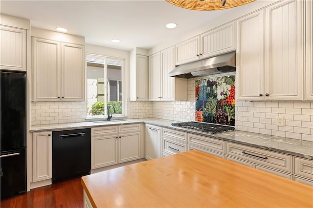 kitchen with decorative backsplash, dark wood-style flooring, under cabinet range hood, black appliances, and a sink