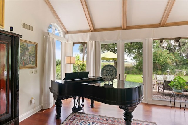 living area featuring visible vents, vaulted ceiling with beams, baseboards, and wood finished floors