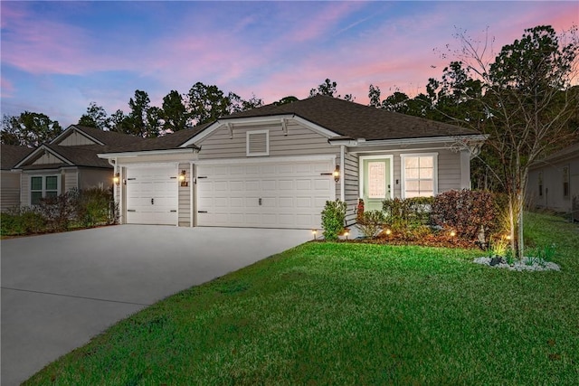 ranch-style home featuring a garage and a yard