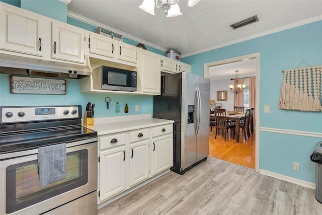 103 Travellers Way, Saint Simons Island, GA 31522 - kitchen with appliances with stainless steel finishes, a chandelier, under cabinet range hood, ornamental molding, and light wood-style floors