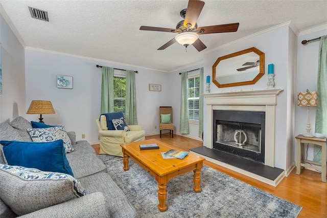 103 Travellers Way, Saint Simons Island, GA 31522 - living area featuring wood finished floors, ornamental molding, ceiling fan, a textured ceiling, and a fireplace with raised hearth