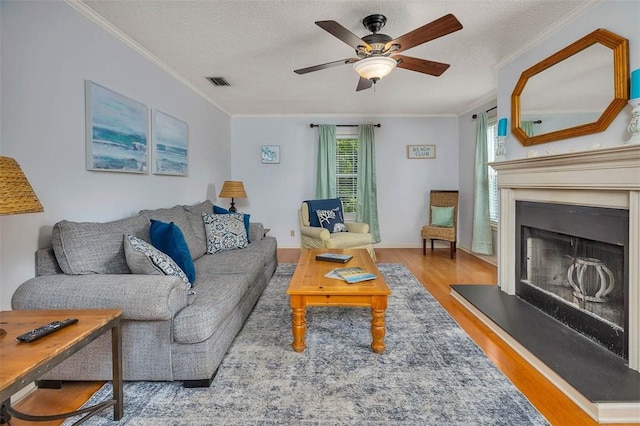 103 Travellers Way, Saint Simons Island, GA 31522 - living area with wood finished floors, a ceiling fan, ornamental molding, a fireplace with raised hearth, and a textured ceiling
