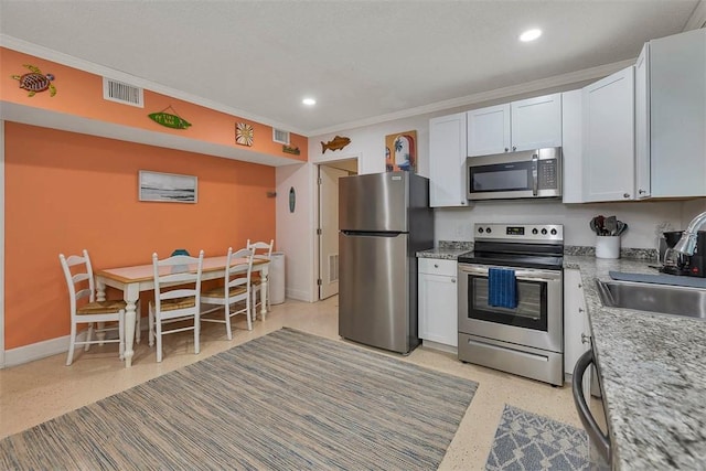 103 Travellers Way, Saint Simons Island, GA 31522 - kitchen featuring appliances with stainless steel finishes, white cabinetry, crown molding, recessed lighting, and light stone counters
