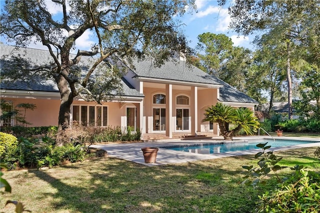 rear view of property with a lawn