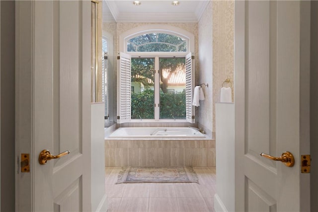 bathroom with tile patterned flooring, a relaxing tiled tub, and crown molding