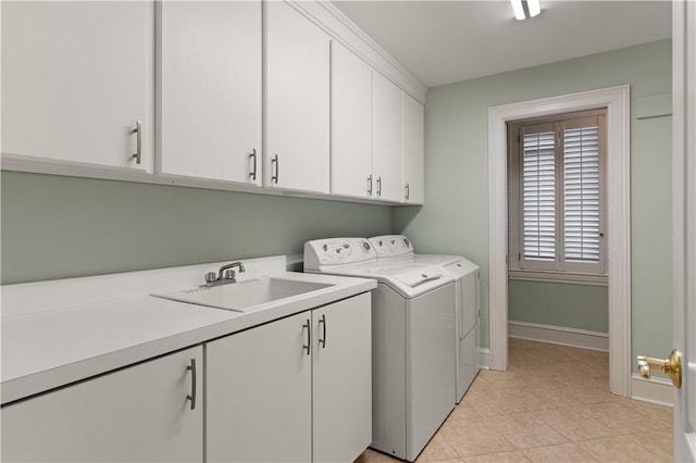 laundry room featuring cabinets, light tile patterned floors, separate washer and dryer, and sink