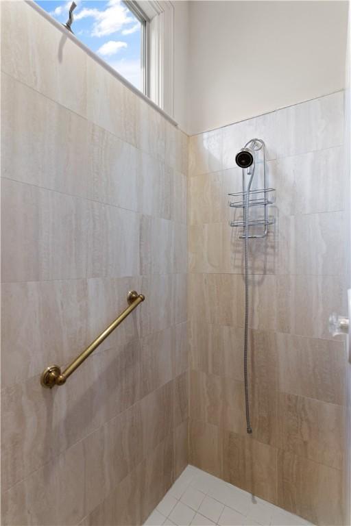 bathroom featuring tiled shower and tile patterned floors