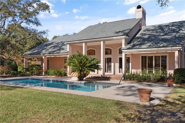 rear view of house with a lawn and a patio