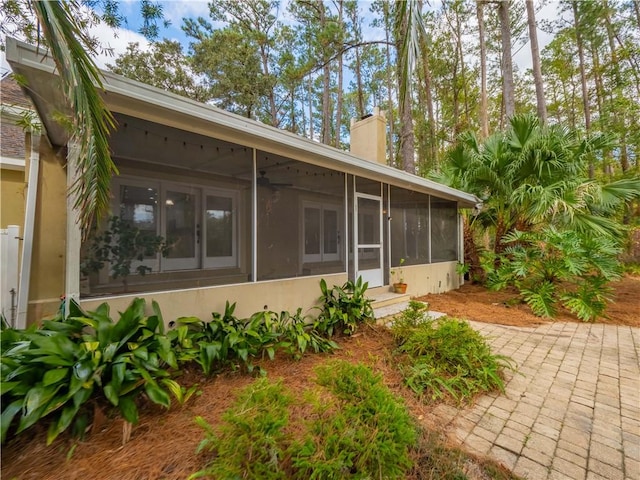 rear view of property featuring a sunroom