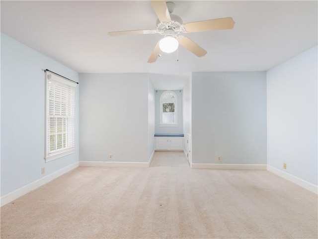 carpeted spare room with a wealth of natural light and ceiling fan