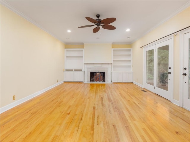 unfurnished living room featuring ceiling fan, light hardwood / wood-style floors, ornamental molding, and a fireplace