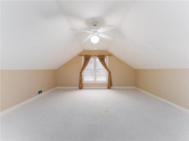 additional living space featuring ceiling fan, lofted ceiling, and light carpet