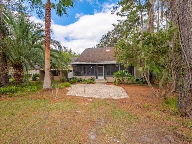 rear view of house with a lawn and a sunroom