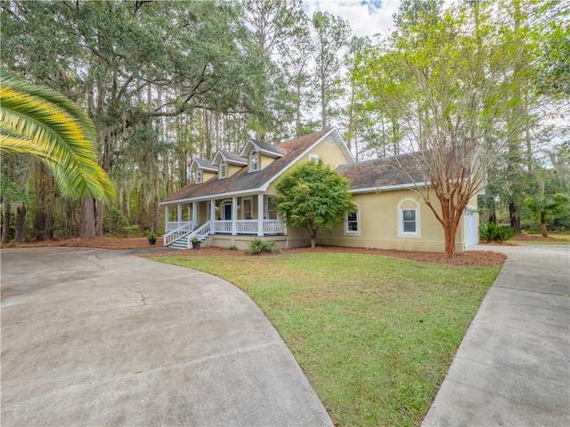 view of front of home with a porch, a garage, and a front lawn