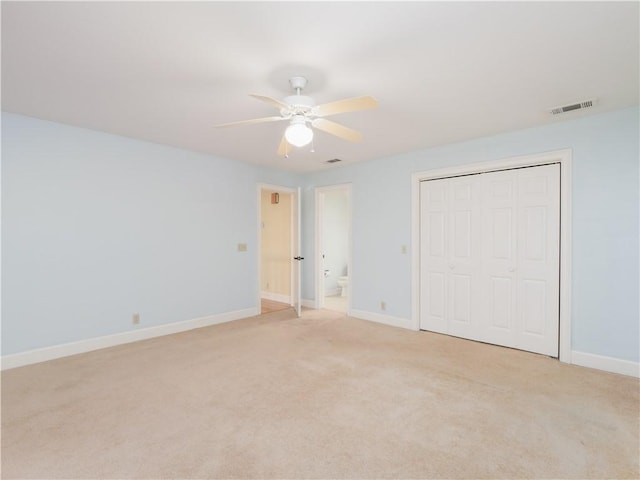 unfurnished bedroom featuring a closet, light colored carpet, and ceiling fan