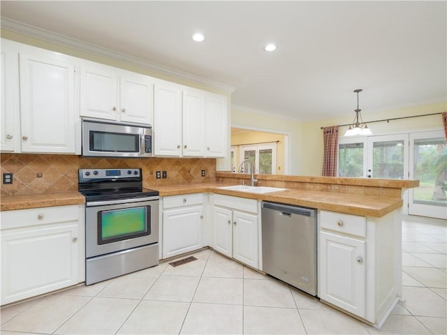 kitchen featuring pendant lighting, white cabinetry, kitchen peninsula, and appliances with stainless steel finishes