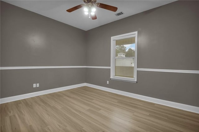 empty room with ceiling fan and light hardwood / wood-style flooring