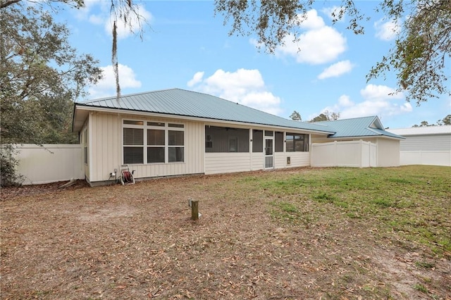 back of house with a sunroom and a yard