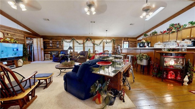 living room with hardwood / wood-style flooring, vaulted ceiling, ceiling fan, and wood walls