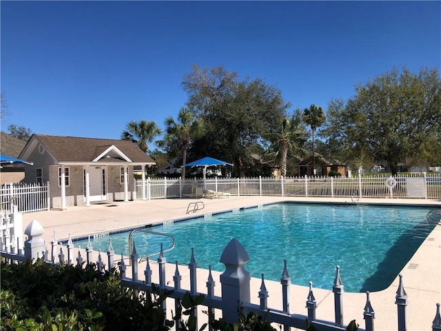 community pool with a patio and fence