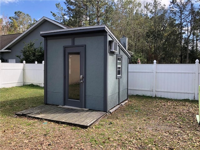 view of outdoor structure featuring an outbuilding and a fenced backyard