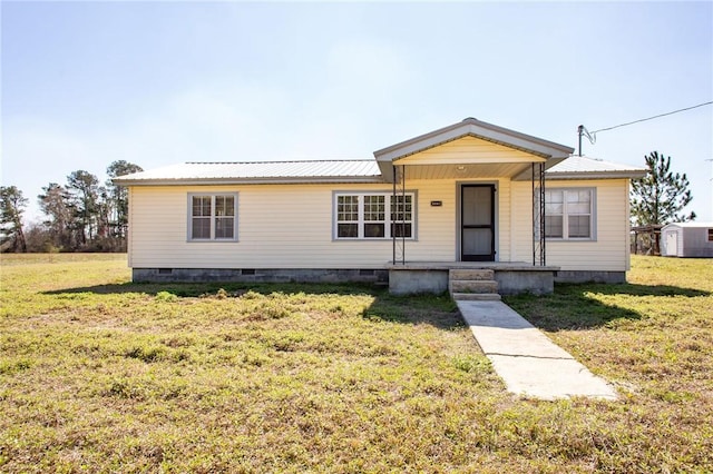 view of front of house featuring crawl space, a front yard, and metal roof